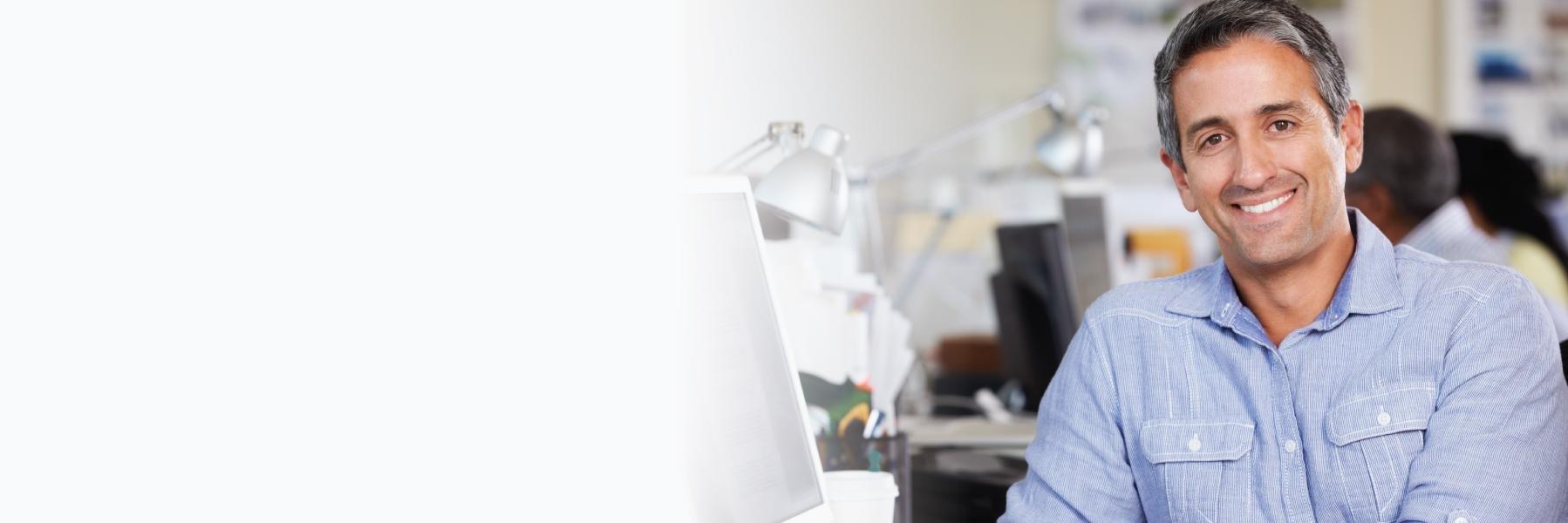 Older man in office smiling after replacing missing teeth in Pikesville, MD