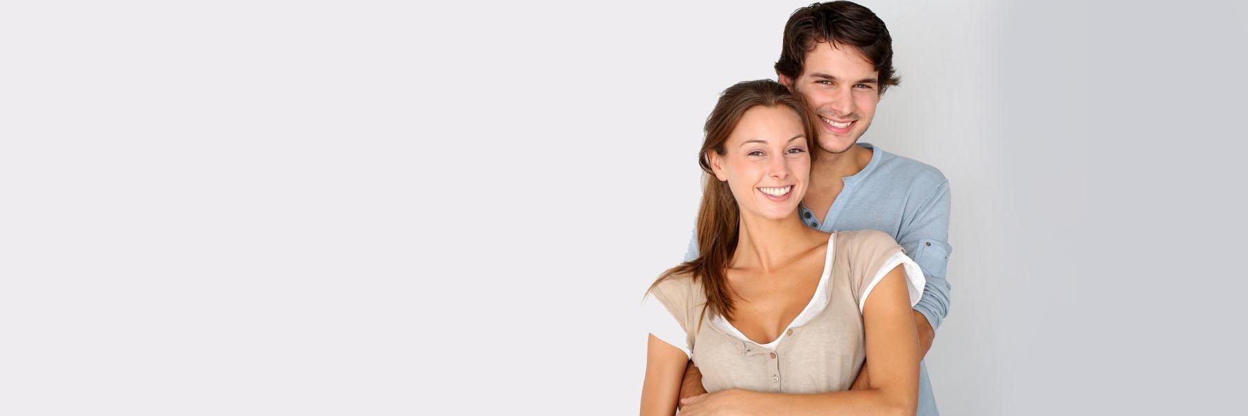 Young couple smiling & hugging after dental treatment in Pikesville MD
