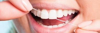 Close up of person flossing her teeth in Pikesville, MD
