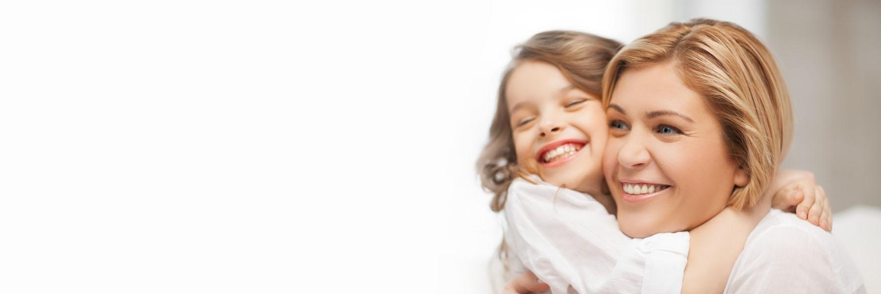 Woman & young daughter hugging & smiling after teeth treatment Naylors Court Dental 