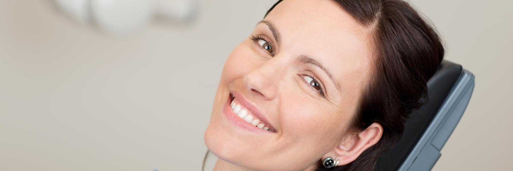 Woman smiling after getting dental crowns Pikesville, MD