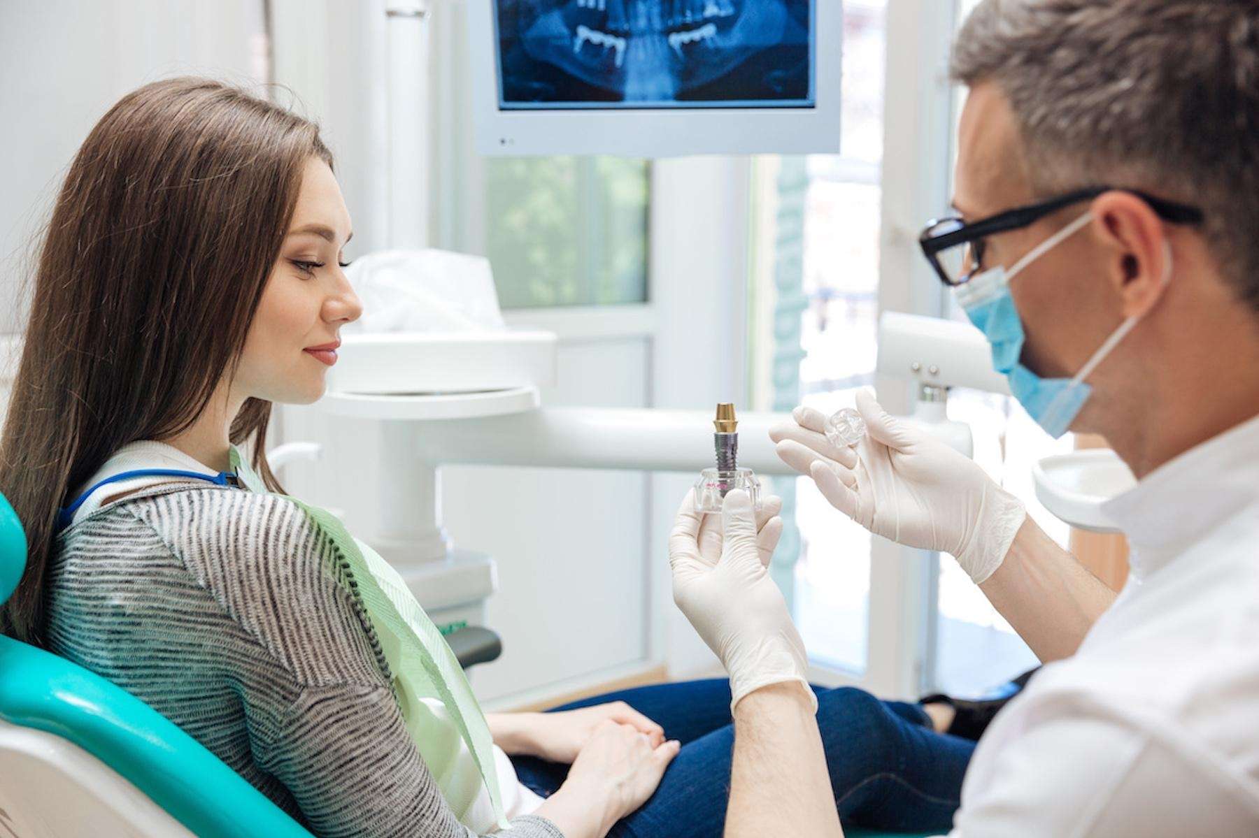 Dentist showing a patient a dental implant in Pikesville, MD