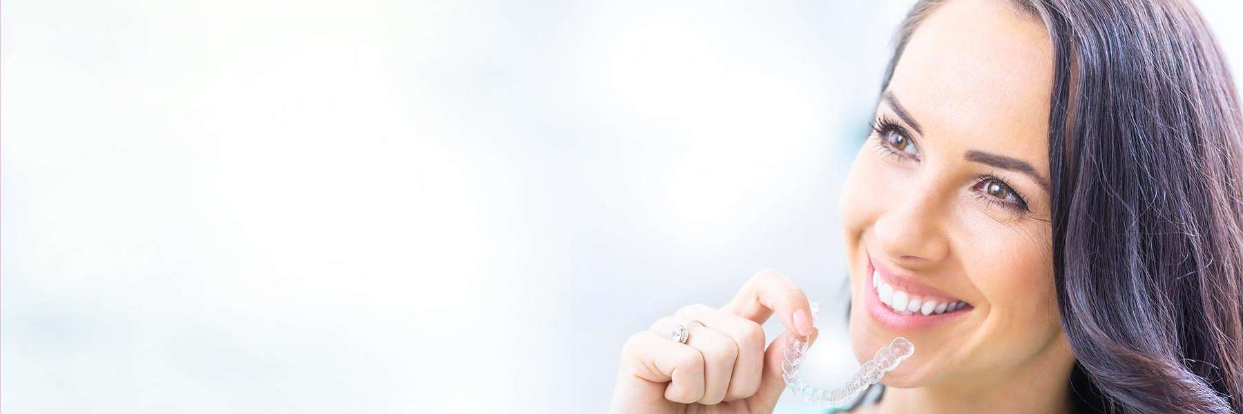 Lady holding Invisalign clear aligners at Naylors Court Dental Partners