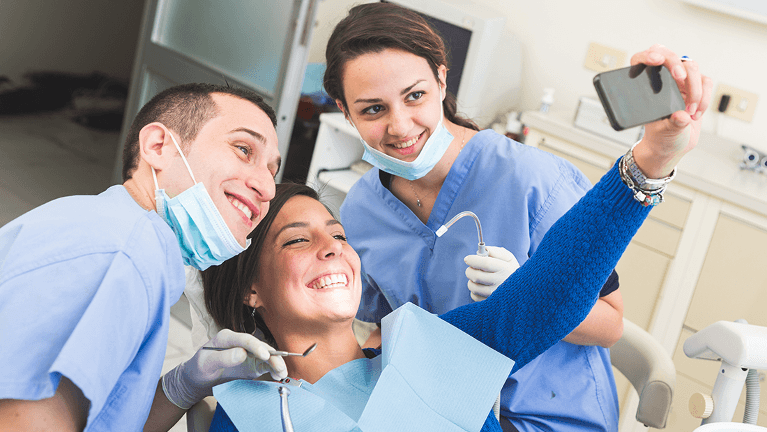 Patient takes a selfie with the dentists after dental treatment in Pikesville, MD