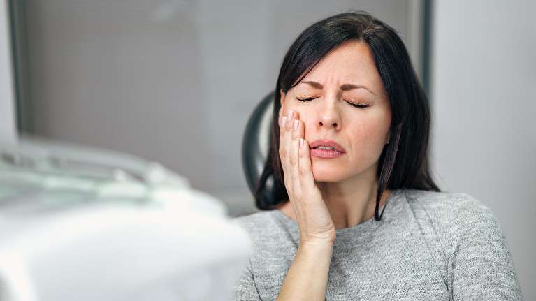 Lady holding her jaw due to migraines in Pikesville, MD