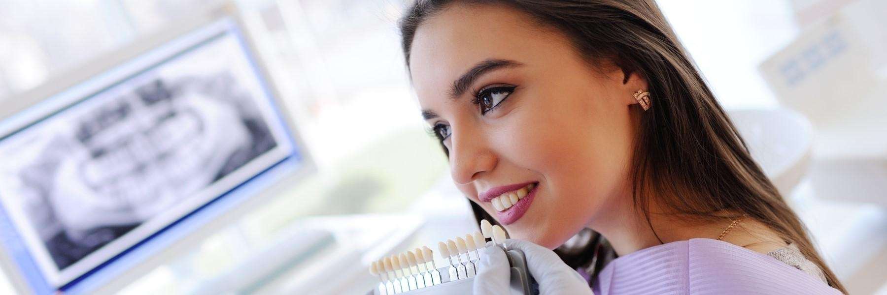 A young lady checking out a teeth color shade in Pikesville, MD 